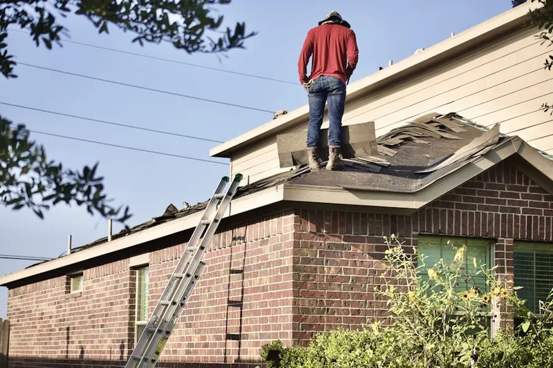 Professional roofer working on a residential roof in Freeman